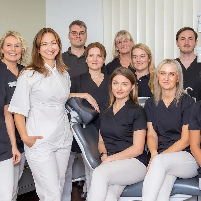 Gruppenfoto des freundlichen Zahnarztteams mit Zahnärzten und Mitarbeiterinnen in der Zahnarztpraxis am Stadtpark in Lübeck. Kompetente Zahnmedizin und persönliche Patientenbetreuung.
